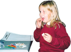 Photograph of a young girl licking a stamp during a school stamp day